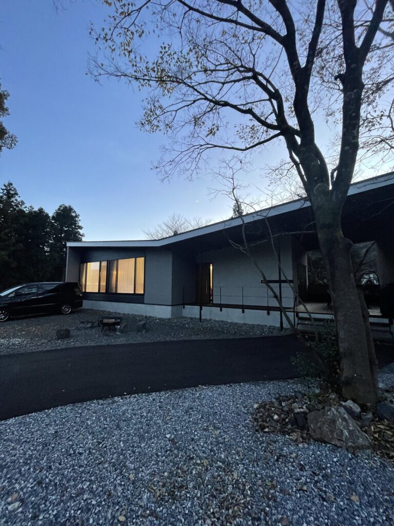 夕暮れのTEF TANIGUMI外観。平屋のヴィラに灯りがともる